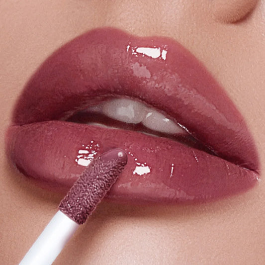 Gros plan sur des lèvres repulpées avec un gloss teinté brillant fini miroir