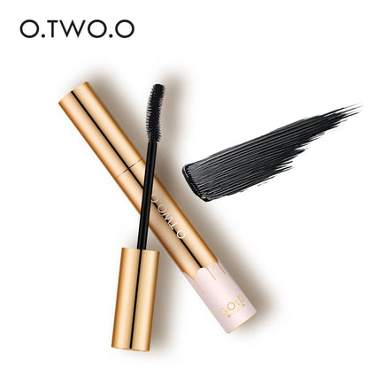Mascara au tube doré luxueux avec brosse applicatrice montrant des cils parfaitement séparés et allongés.
