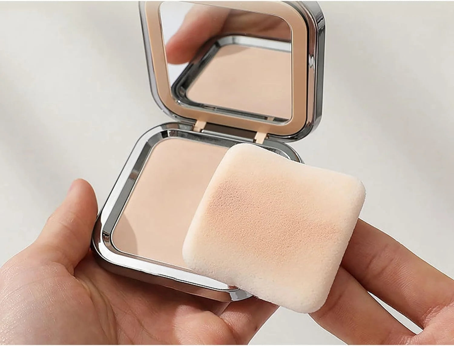 Lot de deux houppettes carrées en velours noir et blanc pour application de fond de teint et poudre libre.
