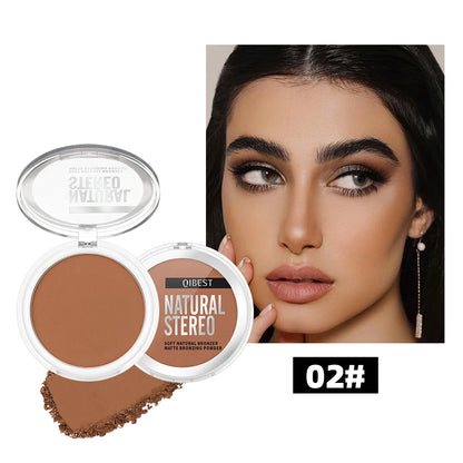 Application d'un bronzer crème mat sur les pommettes pour un contouring naturel et défini.
