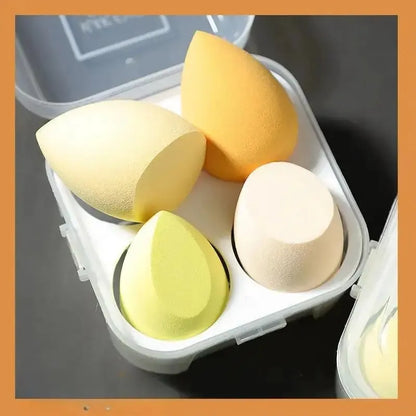 Boîtier contenant 4 éponges de maquillage en forme d'œuf de différentes couleurs pour l'application du teint.