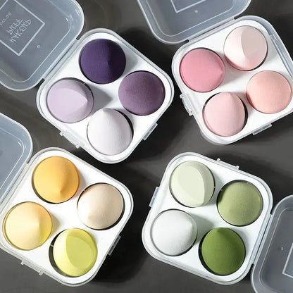 Boîtier contenant 4 éponges de maquillage en forme d'œuf de différentes couleurs pour l'application du teint.