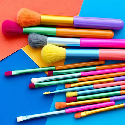 Collection de 15 pinceaux de maquillage aux manches colorés et poils dégradés pour le visage et les yeux.
