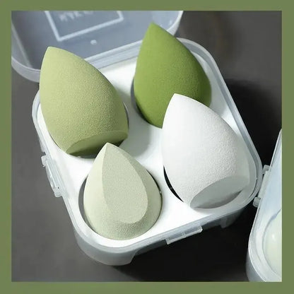 Boîtier contenant 4 éponges de maquillage en forme d'œuf de différentes couleurs pour l'application du teint.