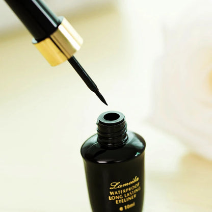 Stylo eyeliner noir à pointe dure réalisant un trait ultra-fin et graphique sur la paupière.
