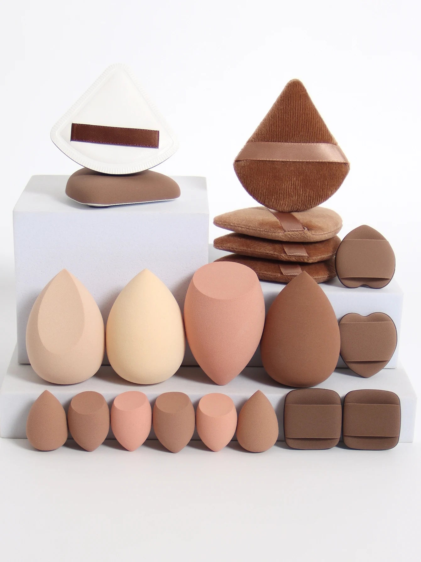 Collection de 20 éponges et houppettes de maquillage roses de différentes formes pour fond de teint et poudre.
