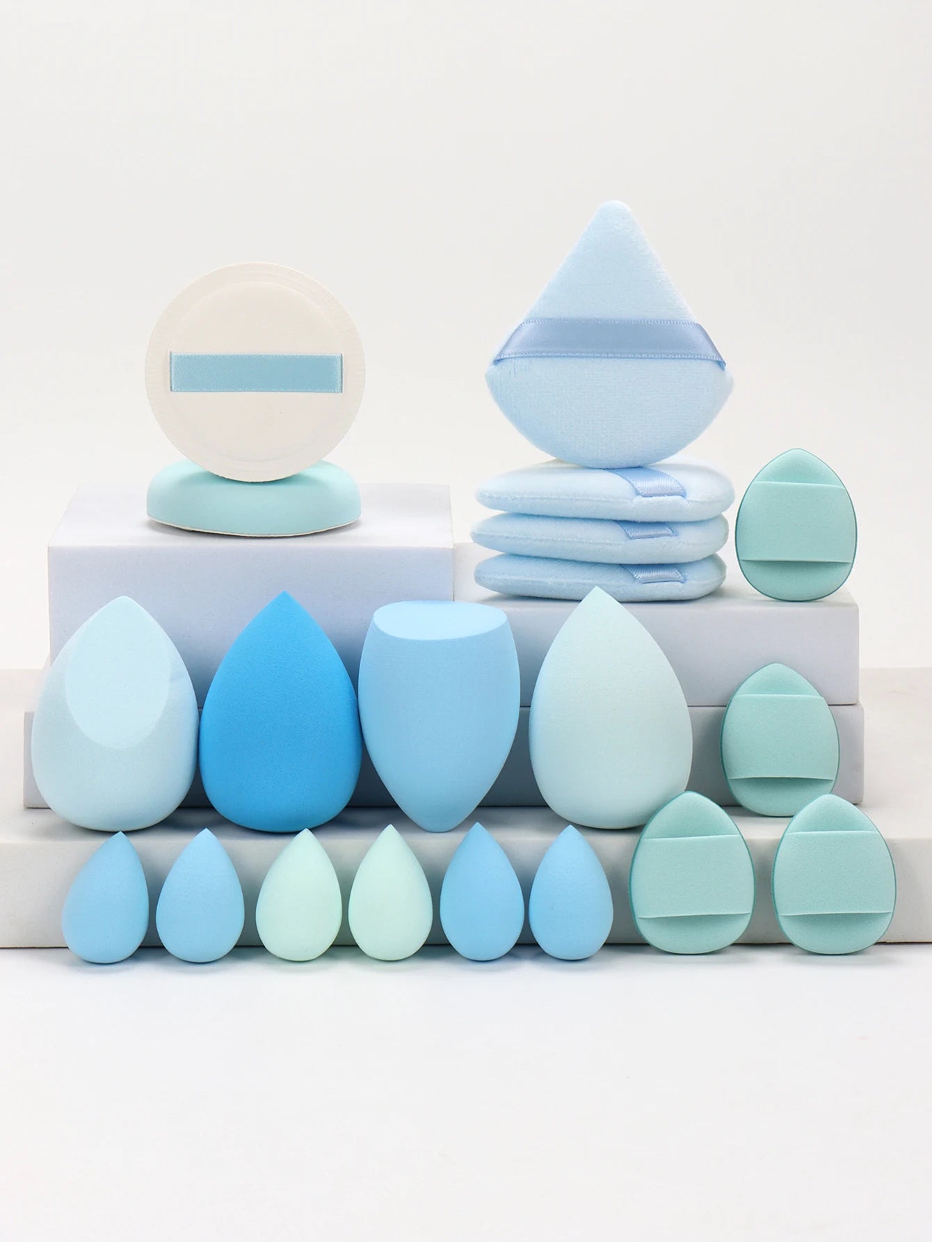 Collection de 20 éponges et houppettes de maquillage roses de différentes formes pour fond de teint et poudre.
