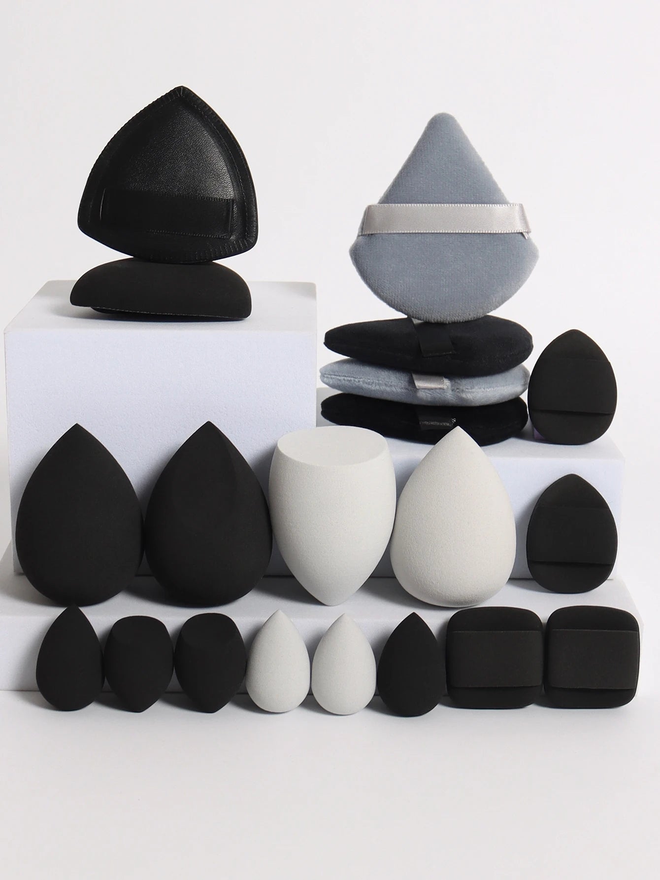 Collection de 20 éponges et houppettes de maquillage roses de différentes formes pour fond de teint et poudre.
